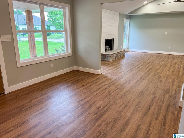 unfurnished living room with vaulted ceiling, wood-type flooring, and a fireplace