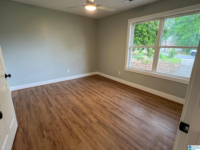 spare room with dark hardwood / wood-style floors and ceiling fan