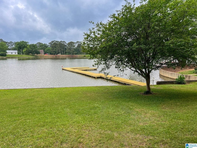 dock area with a water view and a lawn