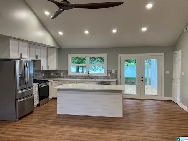 kitchen with sink, stainless steel appliances, white cabinets, a kitchen island, and french doors