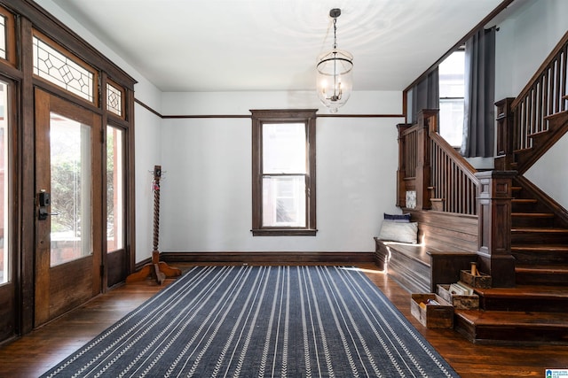 foyer entrance featuring dark hardwood / wood-style flooring and an inviting chandelier