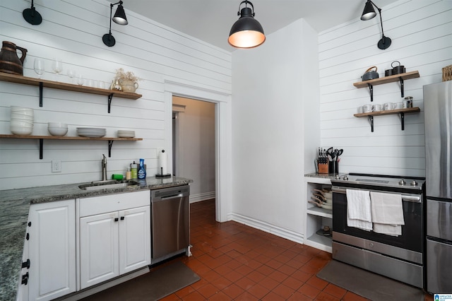 bar with sink, appliances with stainless steel finishes, hanging light fixtures, white cabinets, and dark stone counters