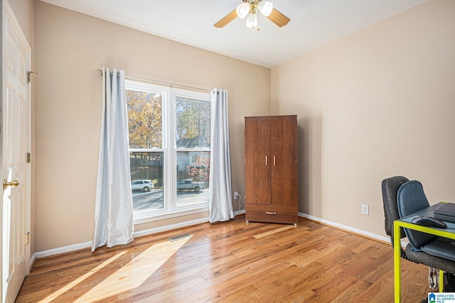 office with light hardwood / wood-style flooring and ceiling fan