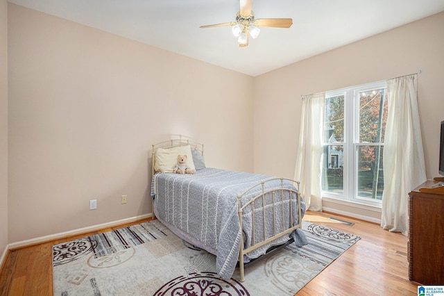 bedroom with light hardwood / wood-style flooring and ceiling fan