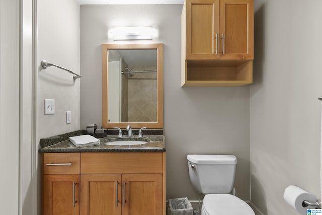 bathroom with vanity, a shower, and toilet