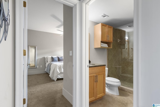 bathroom with vanity, tiled shower, tile patterned floors, and toilet