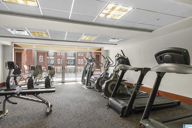 exercise room with a paneled ceiling and french doors