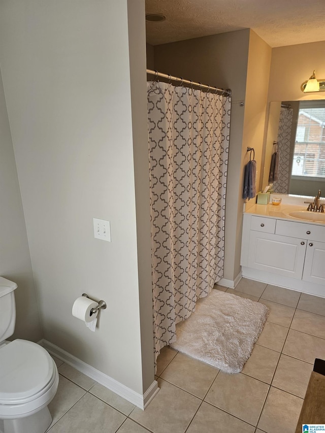 bathroom featuring vanity, tile patterned floors, and a textured ceiling