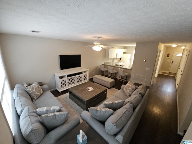 living room with ceiling fan, hardwood / wood-style flooring, and a textured ceiling