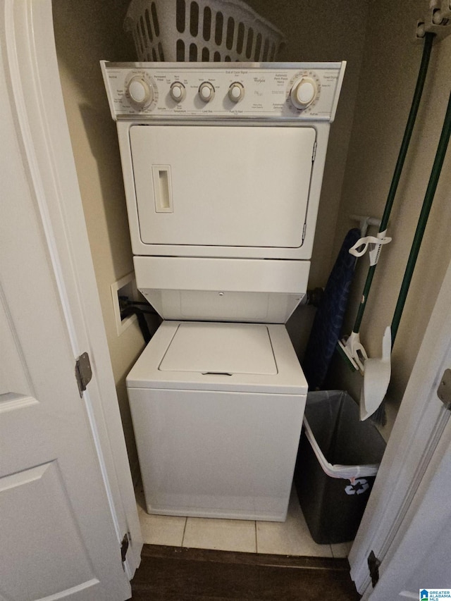 clothes washing area with tile patterned floors and stacked washer and clothes dryer