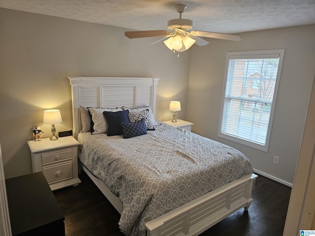 bedroom with ceiling fan, dark hardwood / wood-style flooring, and a textured ceiling