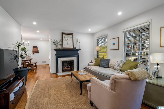 living room with a chandelier and light hardwood / wood-style floors