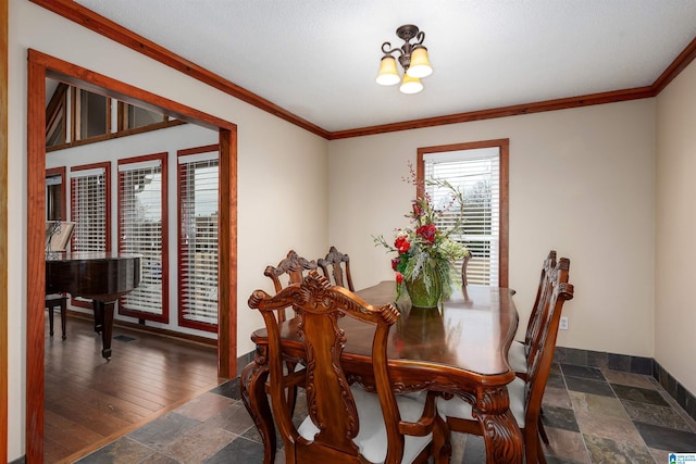 dining space with crown molding and a chandelier