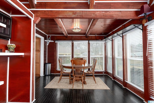 dining area featuring dark wood-type flooring, beam ceiling, and wooden ceiling