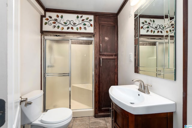 bathroom with vanity, toilet, an enclosed shower, and tile patterned flooring