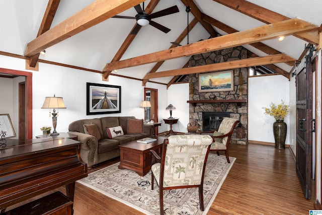 living room featuring a stone fireplace, vaulted ceiling with beams, hardwood / wood-style floors, and ceiling fan