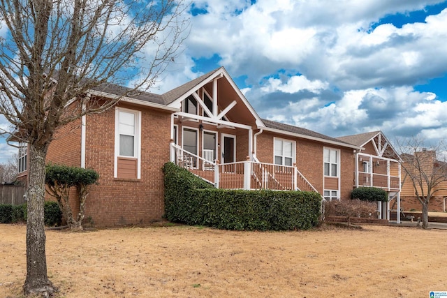 rear view of house featuring a yard and a porch