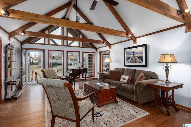 living room with wood-type flooring, lofted ceiling with beams, and ceiling fan