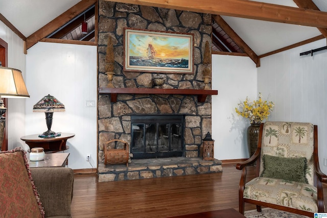 living room featuring lofted ceiling with beams, a stone fireplace, and hardwood / wood-style floors