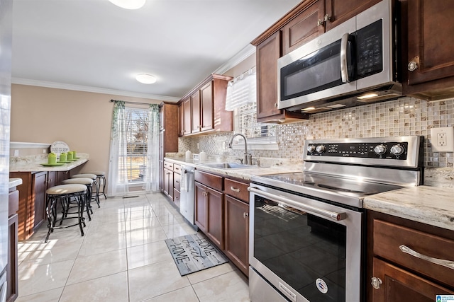 kitchen featuring backsplash, ornamental molding, stainless steel appliances, and a sink