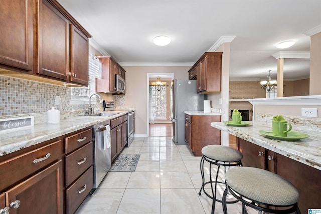 kitchen with hanging light fixtures, appliances with stainless steel finishes, a chandelier, and a sink