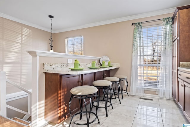 bar with hanging light fixtures, plenty of natural light, visible vents, and crown molding