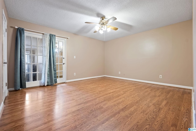 unfurnished room with light wood-style flooring, a textured ceiling, baseboards, and a ceiling fan