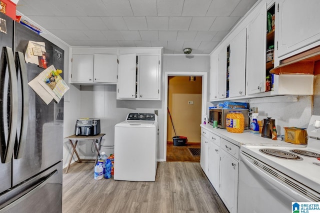 kitchen with white cabinets, light countertops, freestanding refrigerator, washer / clothes dryer, and white electric range oven