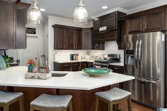 kitchen featuring hanging light fixtures, appliances with stainless steel finishes, sink, and decorative backsplash