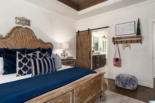 bedroom featuring connected bathroom, wood-type flooring, ornamental molding, a raised ceiling, and a barn door