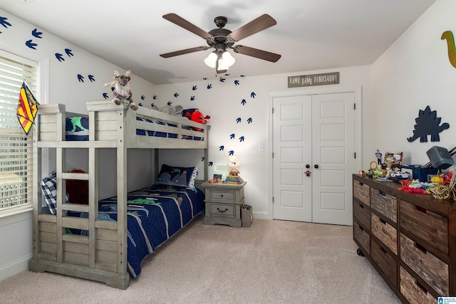 carpeted bedroom featuring ceiling fan and a closet