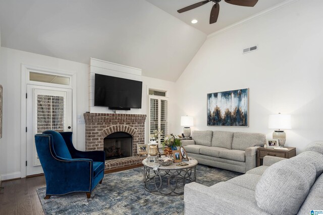 living room with dark hardwood / wood-style flooring, high vaulted ceiling, ceiling fan, and a fireplace