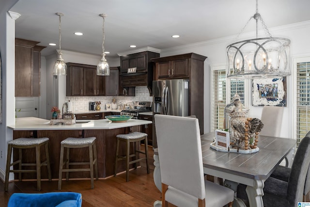 kitchen with sink, decorative light fixtures, appliances with stainless steel finishes, dark hardwood / wood-style flooring, and decorative backsplash