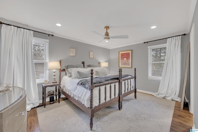 bedroom with multiple windows, hardwood / wood-style flooring, crown molding, and ceiling fan