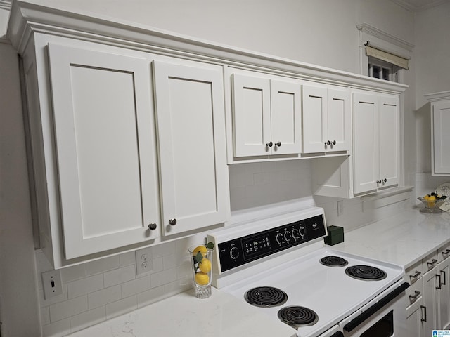 kitchen with electric stove, white cabinetry, tasteful backsplash, and light stone countertops