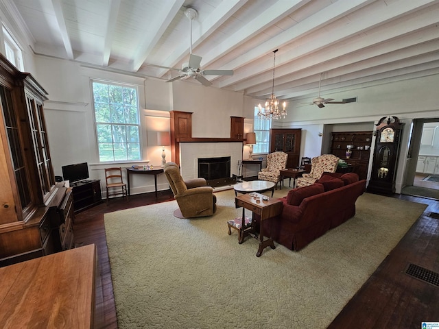 living room featuring dark hardwood / wood-style floors, ceiling fan with notable chandelier, and beam ceiling