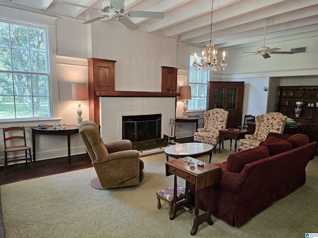 living room with ceiling fan, a brick fireplace, wood-type flooring, and beam ceiling