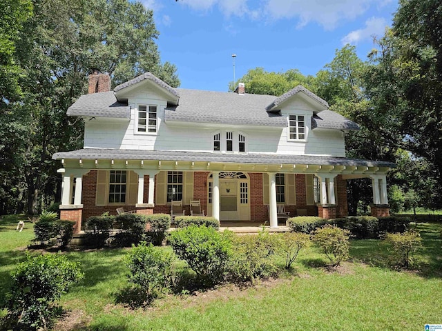 view of front of house featuring covered porch and a front lawn