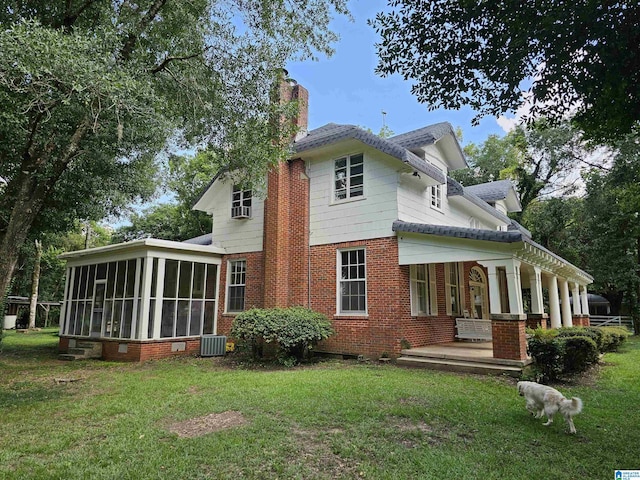 back of house featuring cooling unit, a yard, and a sunroom