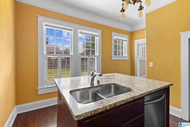 kitchen with dishwasher, an island with sink, sink, light stone counters, and dark wood-type flooring