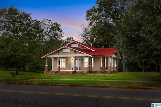 craftsman house featuring covered porch and a lawn