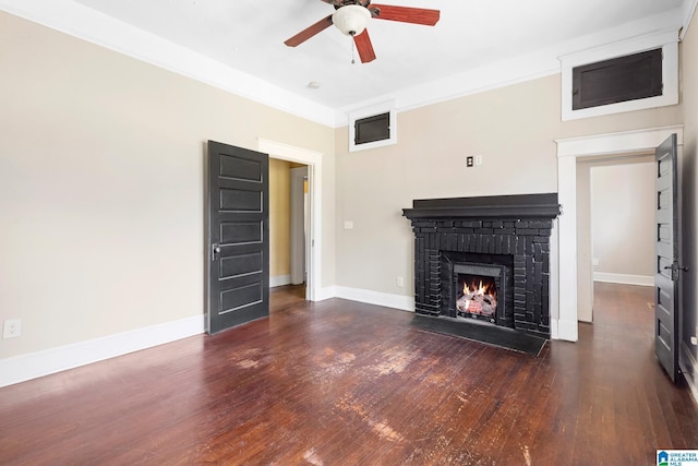 unfurnished living room with dark wood-type flooring, ceiling fan, and a brick fireplace