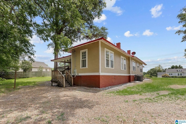 view of front of house featuring central AC and a front lawn