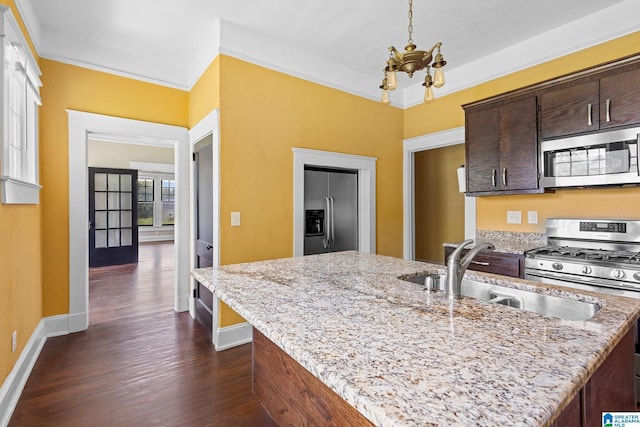 kitchen with stainless steel appliances, dark brown cabinets, sink, and light stone counters