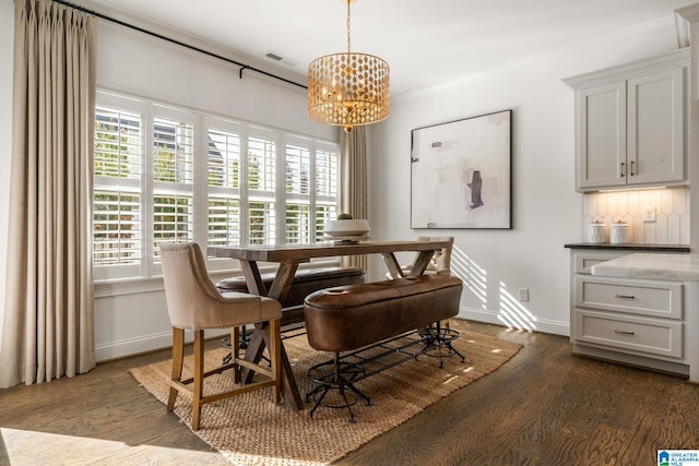 dining space with crown molding, dark wood-type flooring, and a notable chandelier