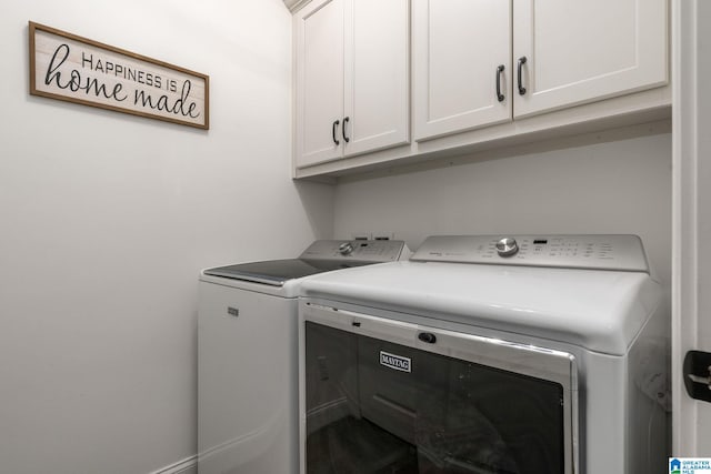 clothes washing area featuring cabinets and washing machine and dryer