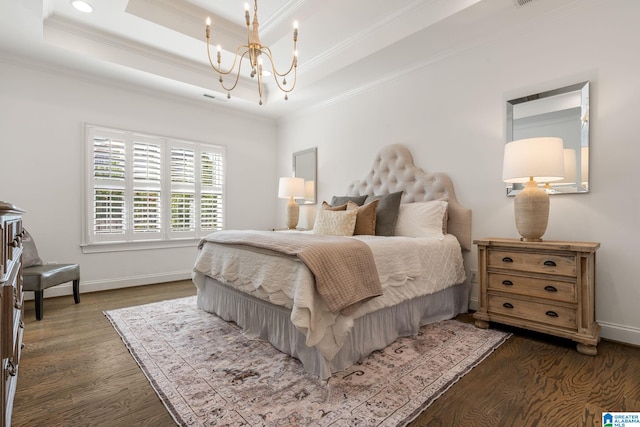 bedroom featuring dark hardwood / wood-style flooring, a tray ceiling, ornamental molding, and a chandelier