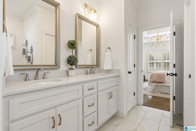 bathroom featuring crown molding, vanity, and a notable chandelier