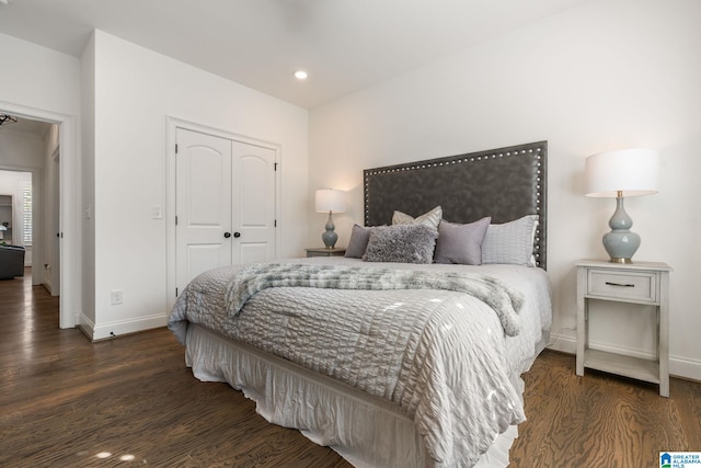 bedroom with dark hardwood / wood-style flooring and a closet