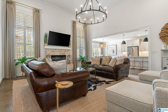 living room featuring hardwood / wood-style flooring, a notable chandelier, and a fireplace